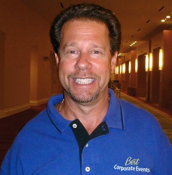 A man in a blue shirt smiling for the camera.