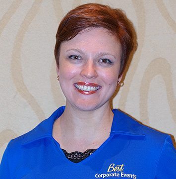 A woman in a blue shirt smiling.