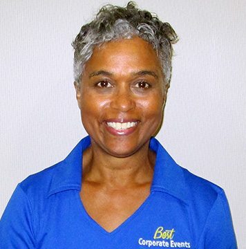 A woman in a blue shirt smiling at the camera.
