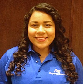 A woman in a blue shirt smiling for the camera.