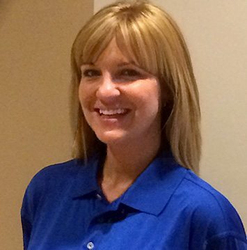 A woman in a blue shirt smiling for the camera.