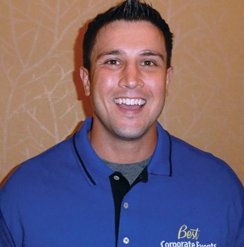 A man in a blue shirt smiling for the camera.