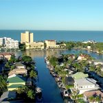 An aerial view of a neighborhood with houses and a body of water.
