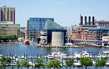 A boat docked in a harbor with buildings in the background.