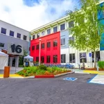 A brightly colored building with a parking lot.