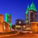 A city at night with a green wall in the background.