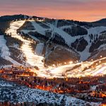 A ski slope lit up at dusk.