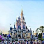 Cinderella's castle in front of a crowd of people.
