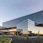 A large glass building with a blue sky in the background.