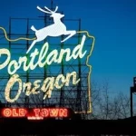 The portland oregon sign is lit up at night.