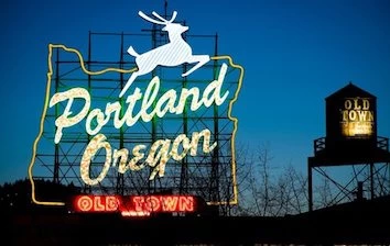 The portland oregon sign is lit up at night.