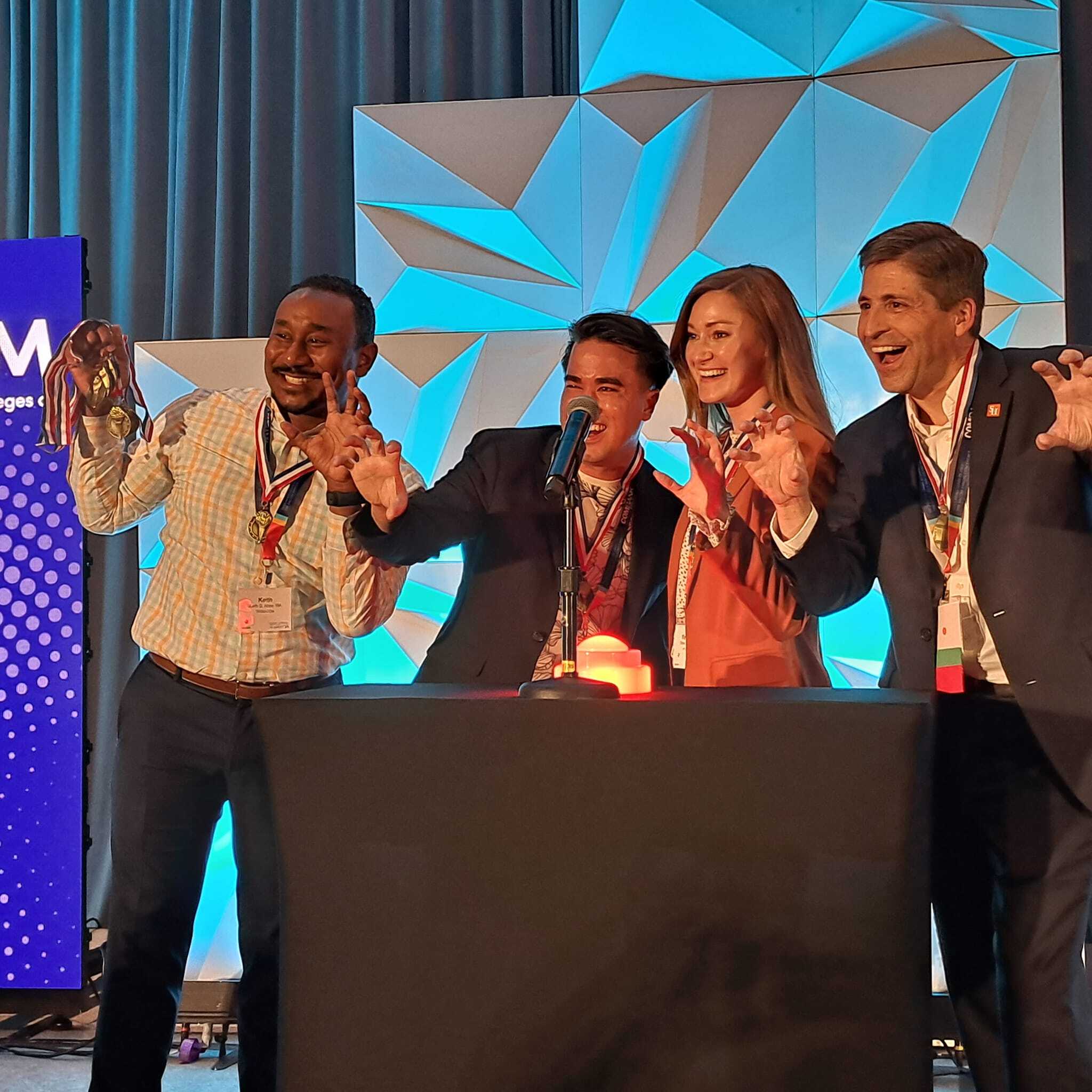 A group of people posing for a picture in front of a stage.