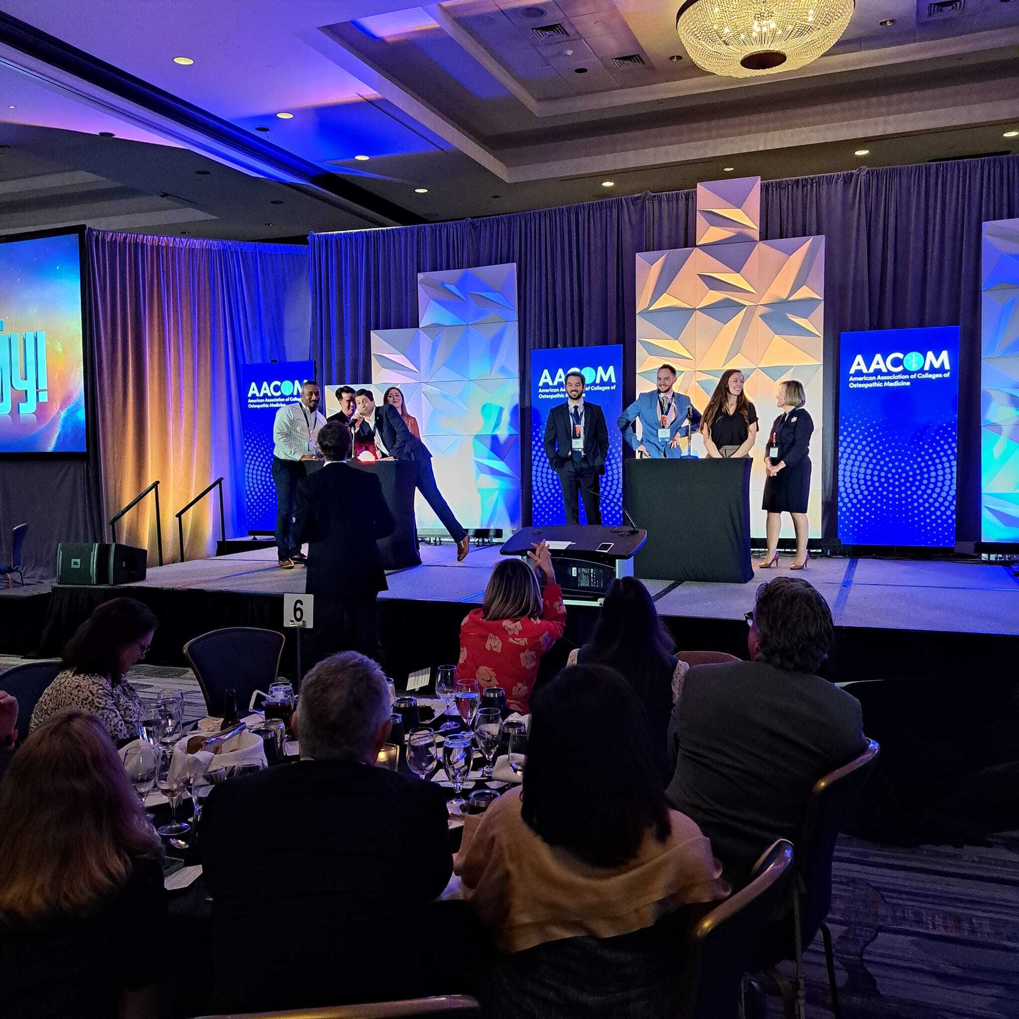 A group of people standing on stage at an event.
