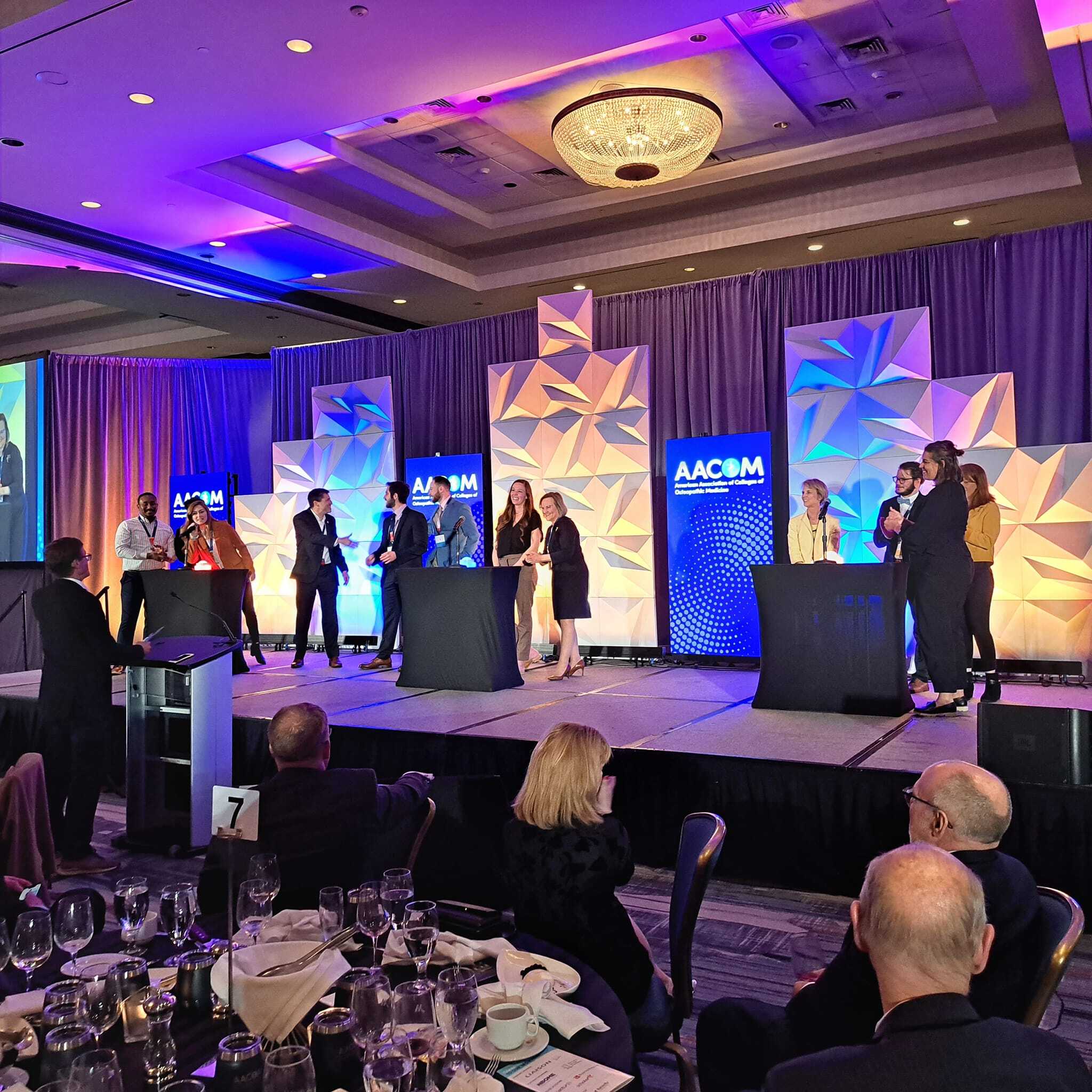 A group of people standing on stage at an event.