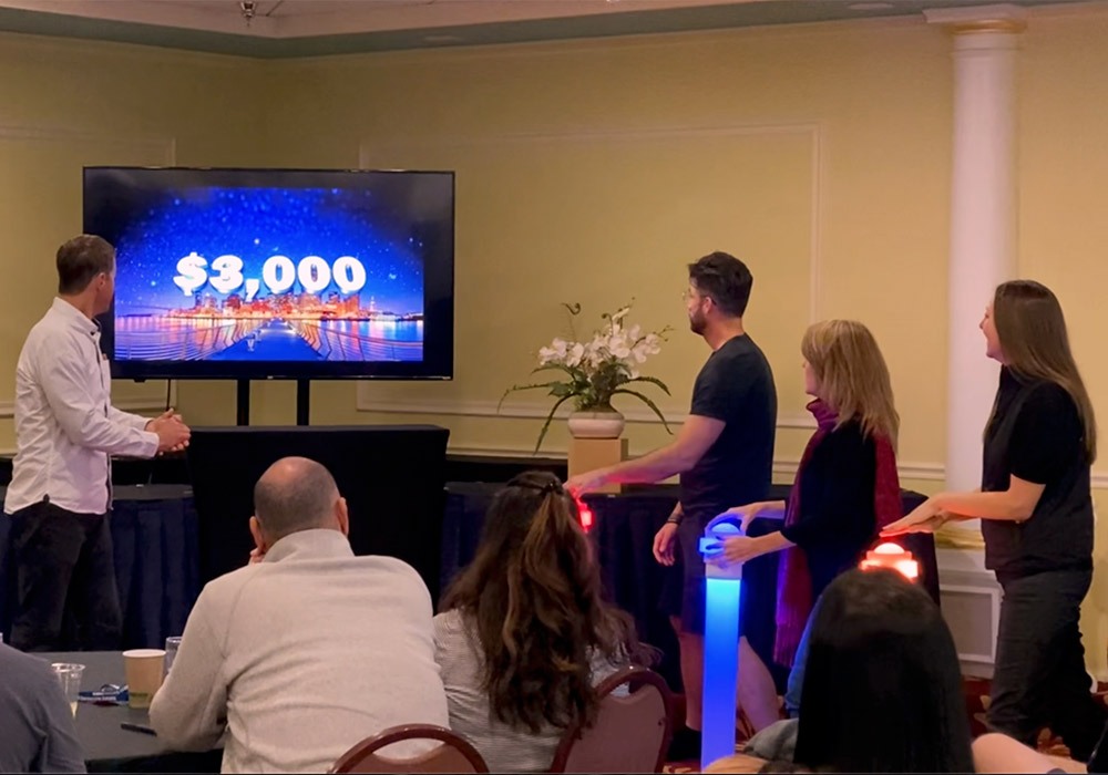 A group of people standing in front of a tv playing a game.