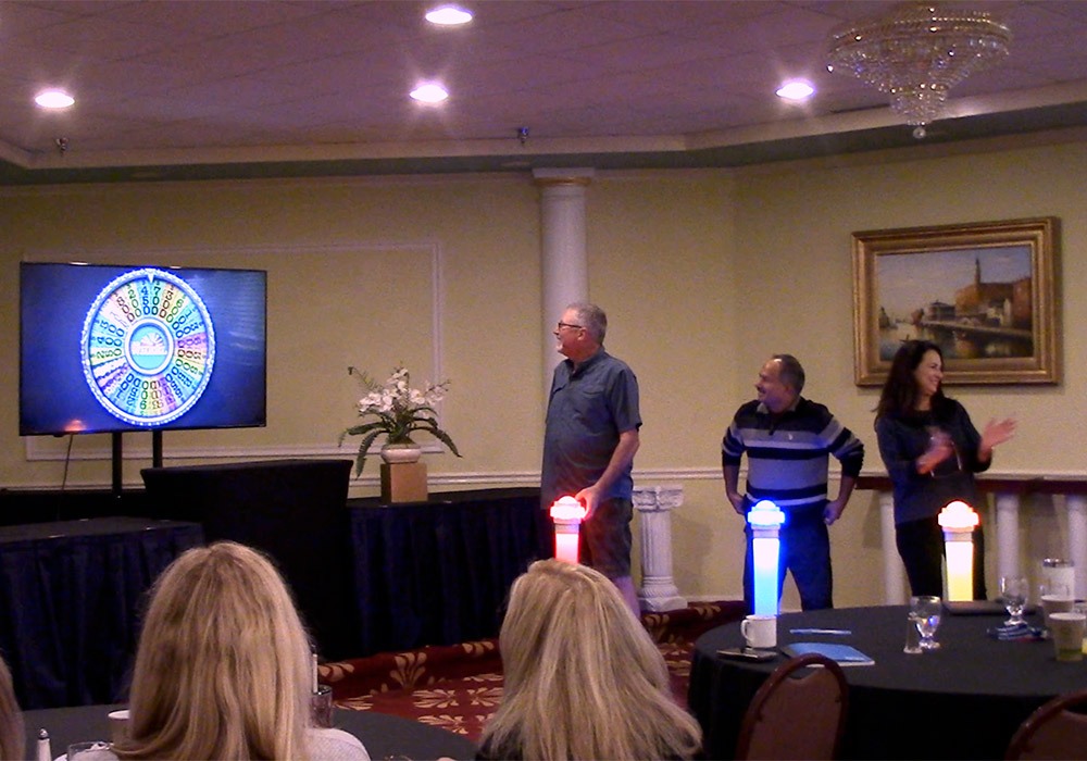 A group of people standing in front of a tv.
