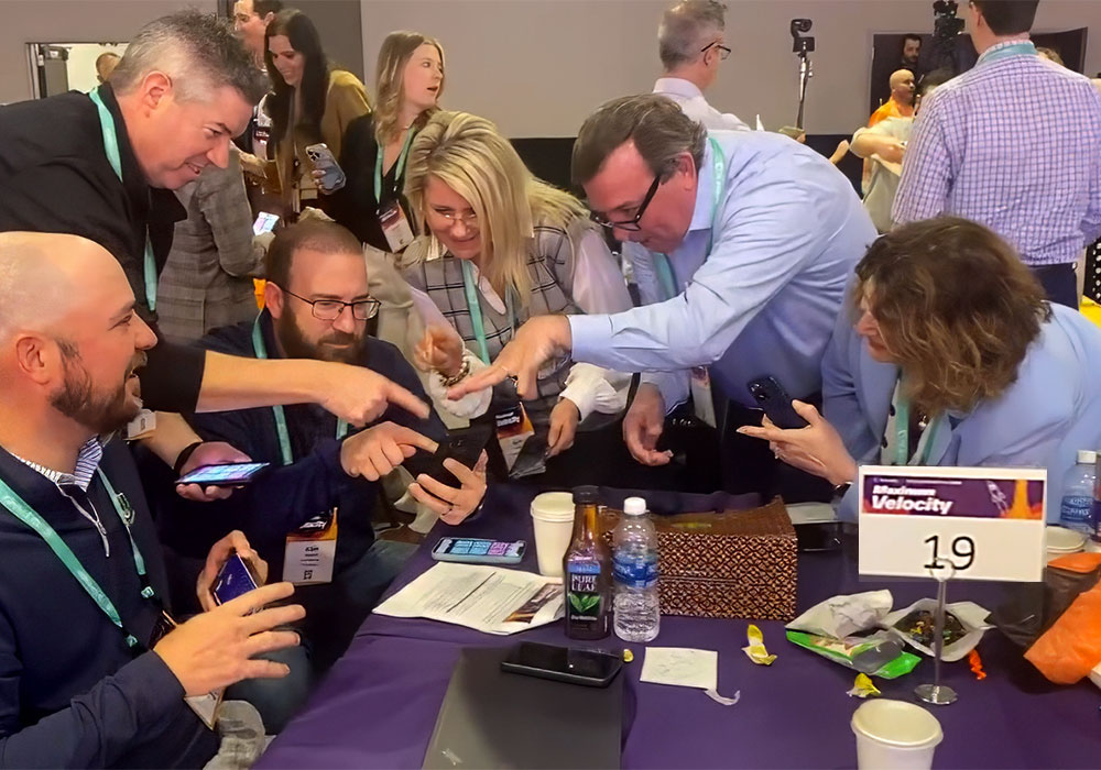 A group of people looking at their phones at a table.