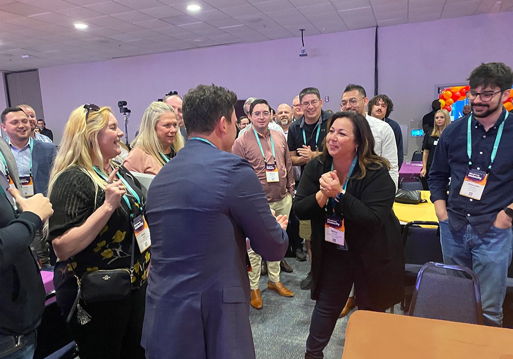 A group of people standing around in a conference room.
