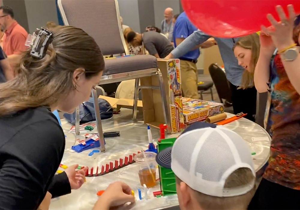 A group of people at a table with balloons and toys.