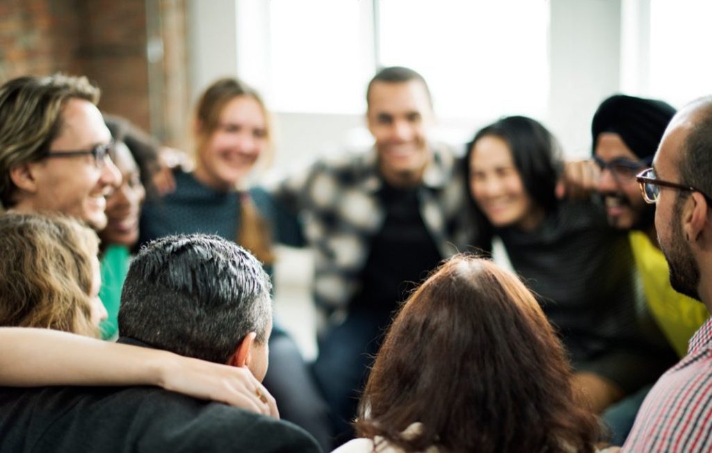 A group of people sitting together in a circle.