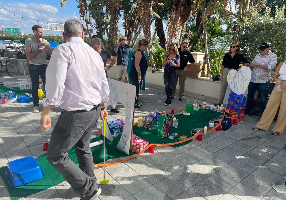 A group of people standing around a group of people playing a game.