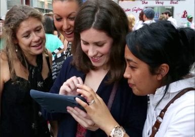 A group of people looking at a tablet computer.