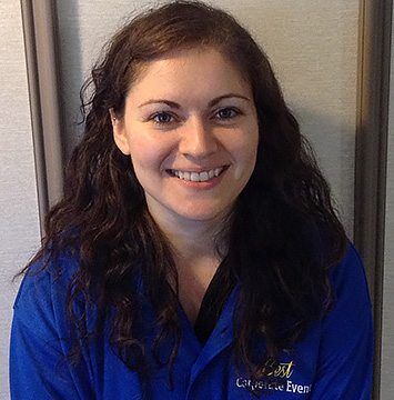 A woman in a blue jacket smiling for the camera.