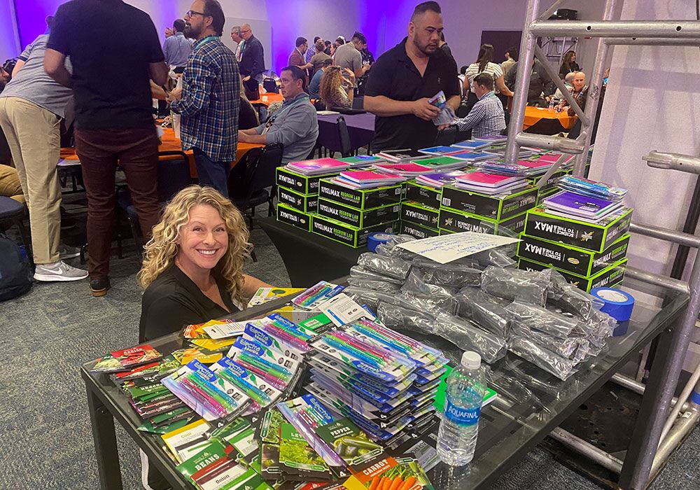 A woman smiling at a table full of pencils.