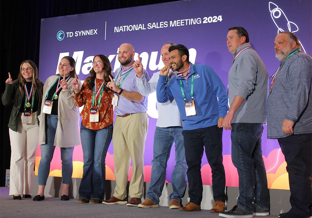A group of people standing on stage at the national sales meeting.