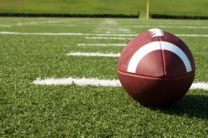 Discover valuable business lessons from the world of sports as you observe a football resting on a vibrant field.