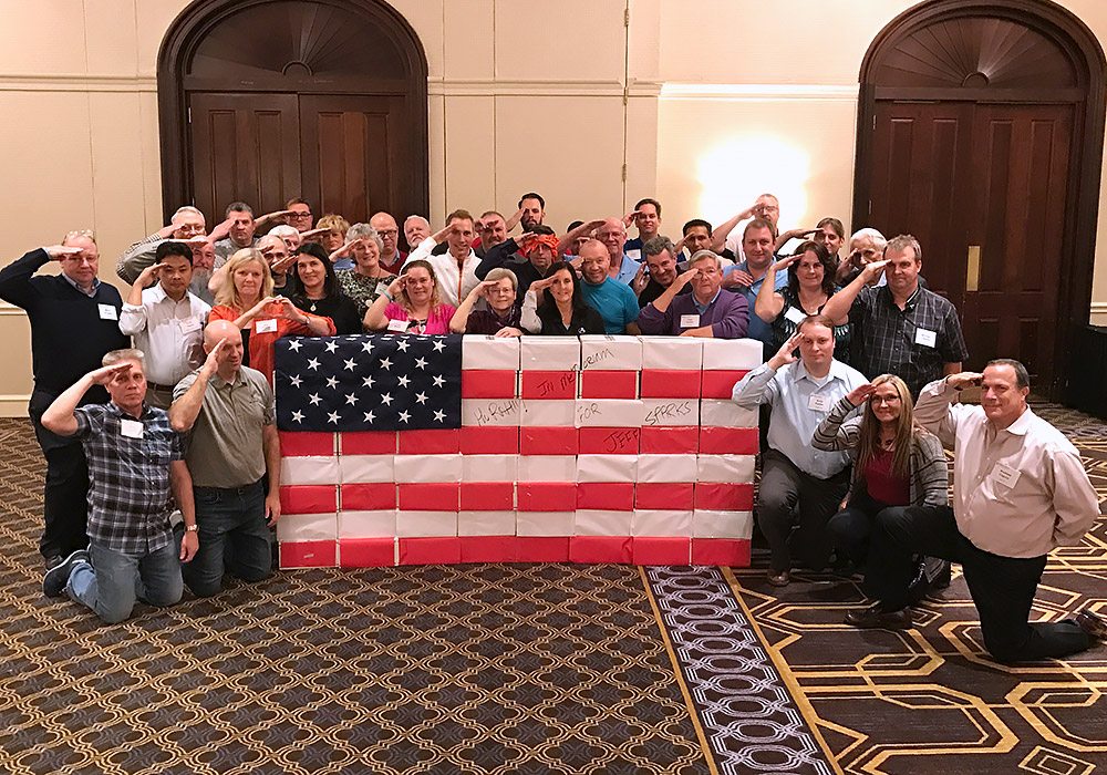A group of people posing with an american flag.
