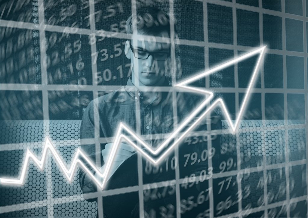 A man is analyzing a graph with an upward arrow, demonstrating the success of his high performing team.