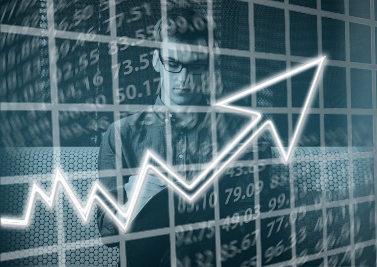 A man is analyzing a graph with an upward arrow, demonstrating the success of his high performing team.