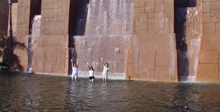 A group of people standing in front of a large waterfall.