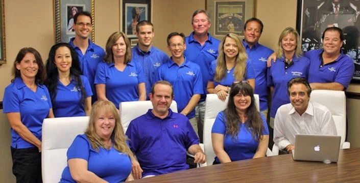 A group of people in blue shirts posing for a picture.