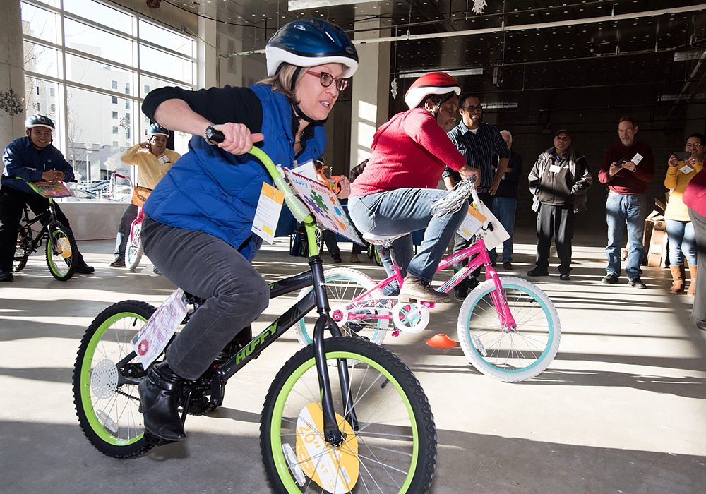 A group of people riding bikes in a large building.