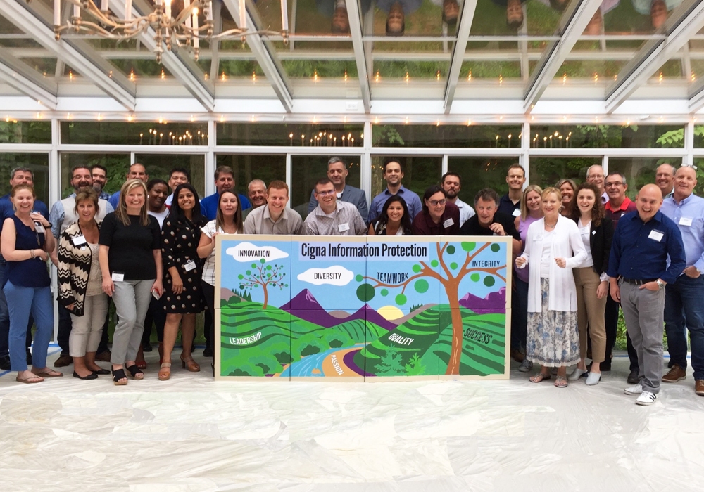 A group of people posing for a picture in front of a sign.