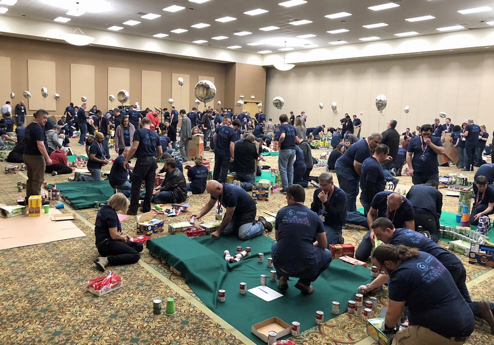 A group of people working on a table in a room.