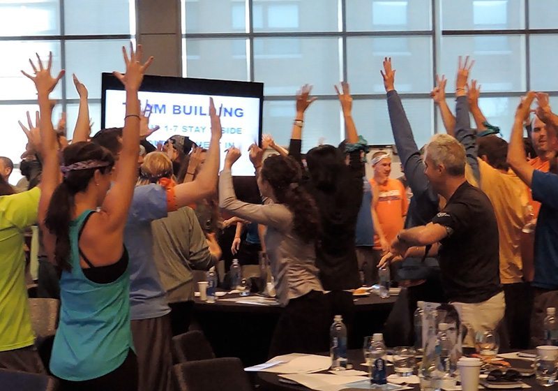 A group of people raising their hands in the air.