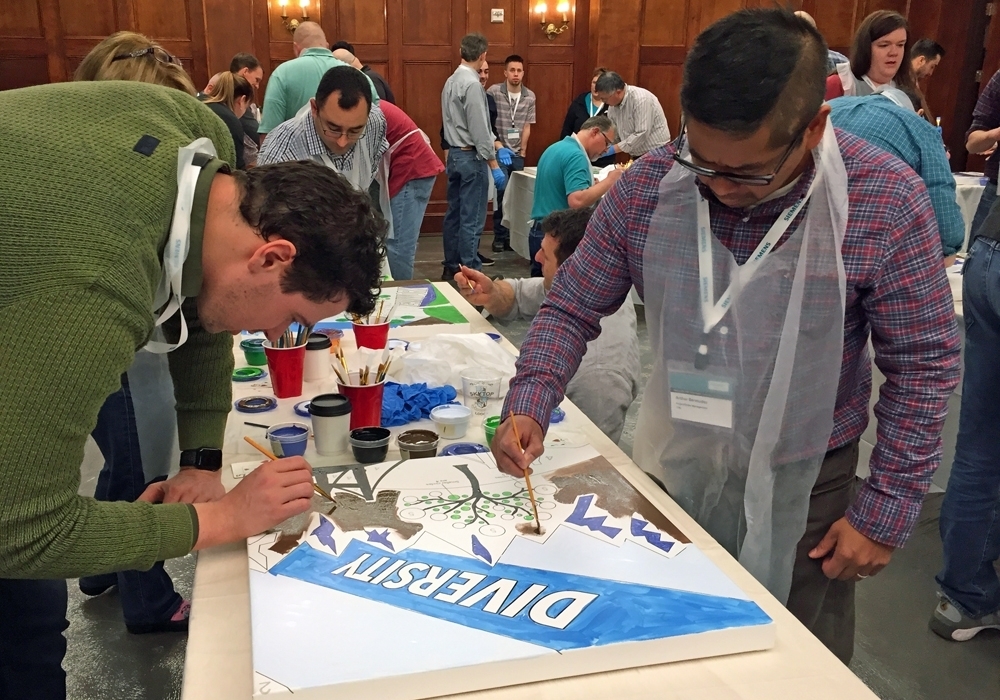 A group of people working on a cake at a convention.
