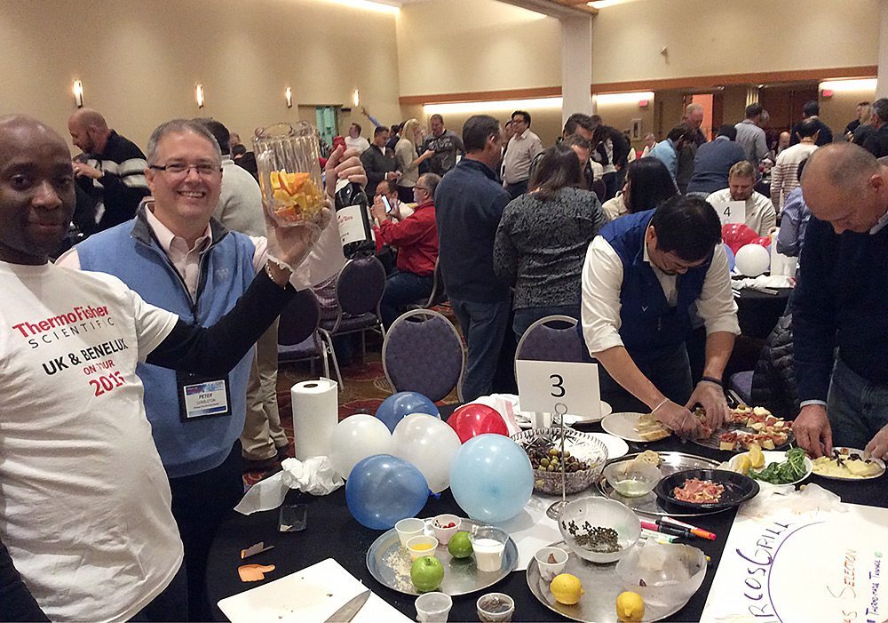 A group of people standing around a table.