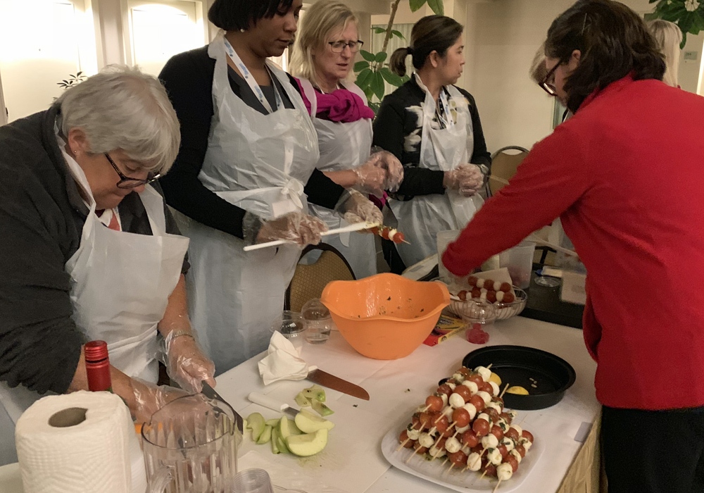 A group of women are preparing food in a kitchen.