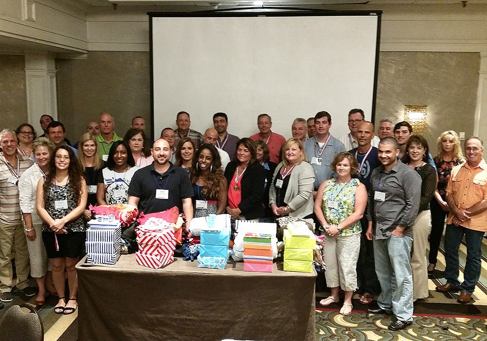 A group of people posing in front of a projector.