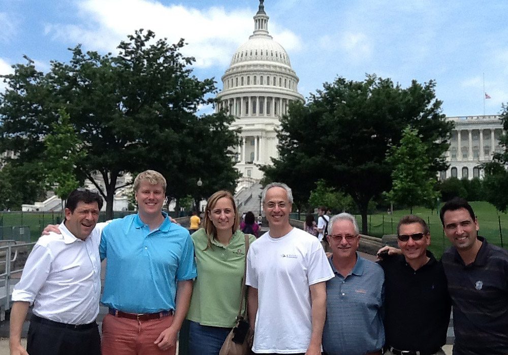 A group of people posing in front of the capitol building.