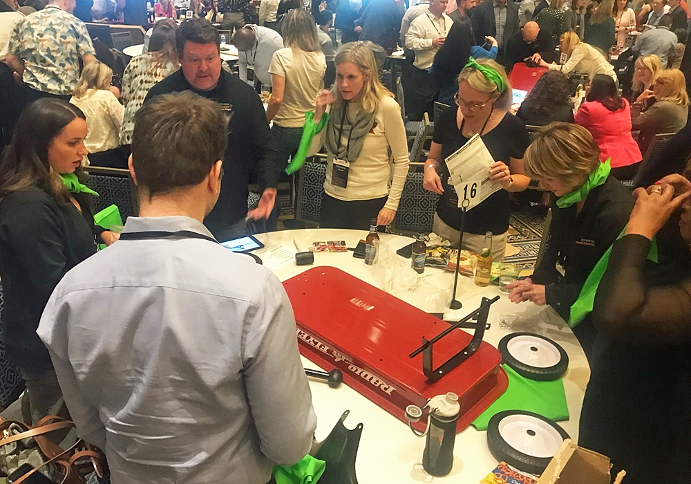 A group of people standing around a table with green ribbons.