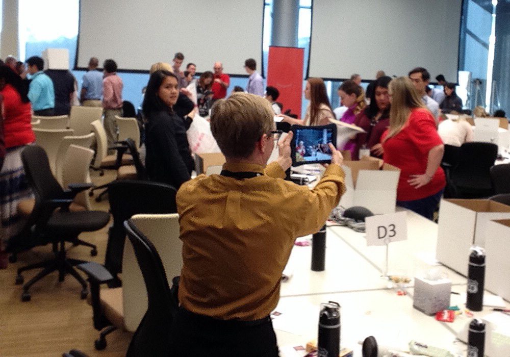 A group of people taking pictures in an office.