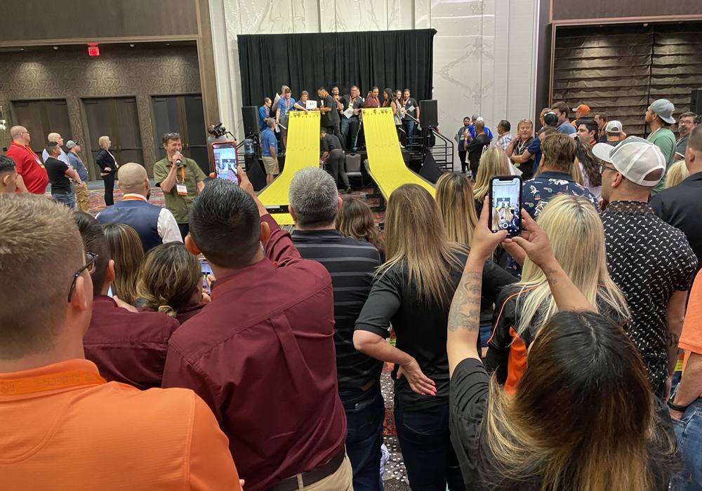 A crowd of people standing in front of a yellow slide.