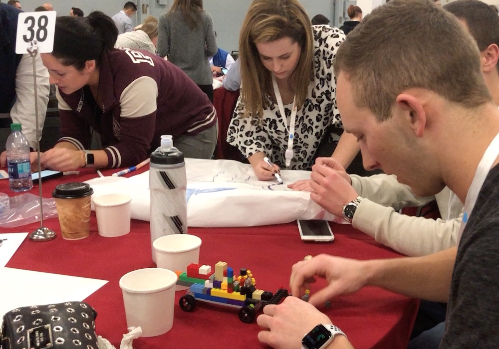 A group of people at a table working on legos.
