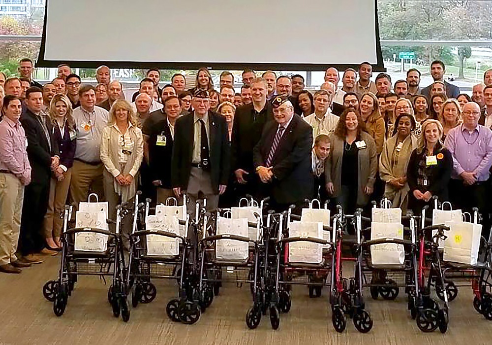 A group of people posing for a picture in front of a projector.