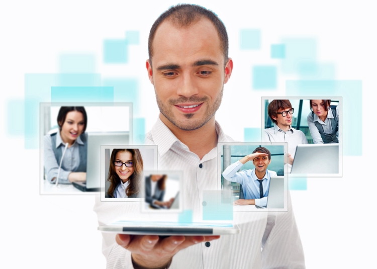 A man holding a tablet with many faces on it.